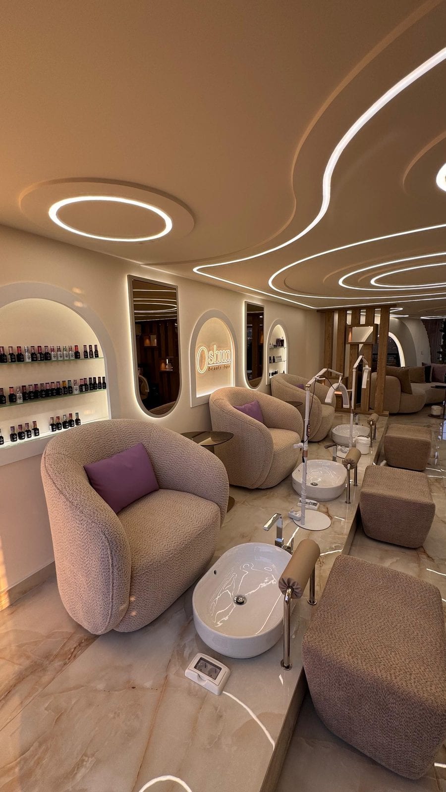 Cream lounge inside Oshun Beauty Spa with arched alcoves and a sculptural lit ceiling